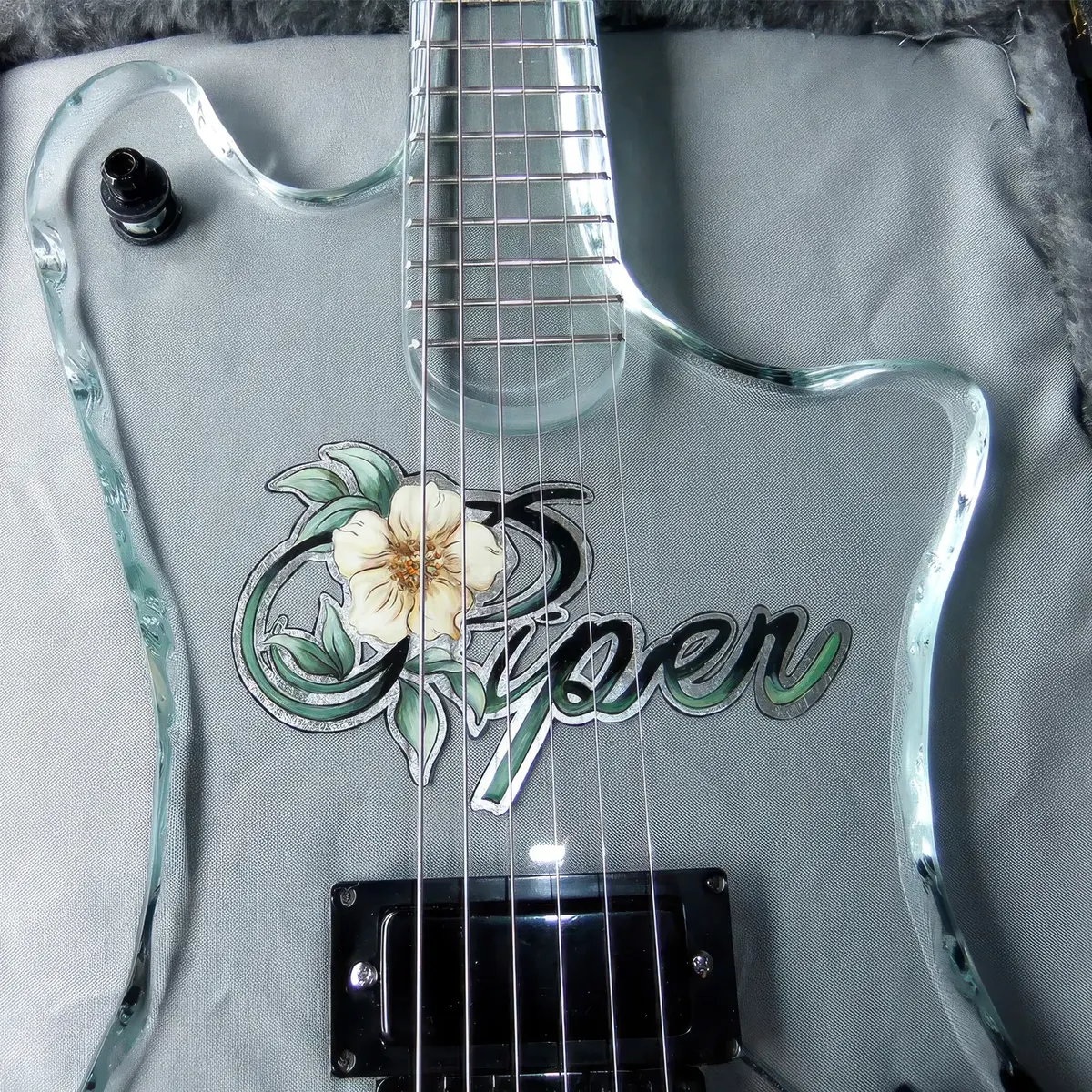 Close-up of the engraved body and bridge of a handcrafted solid-glass electric guitar